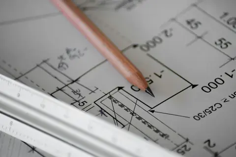 Lápis sobre uma planta de arquitetura com cotas