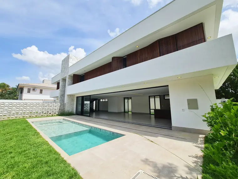 Casa Contemporânea, construída pela Concretá no Portal do Sol II: fachada branca com piscina e jardim