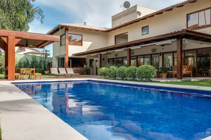 Casa Ipê, no Alphaville Ipê: piscina e varanda com pergolado de madeira